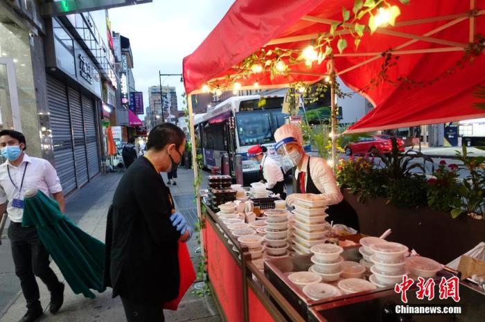 资料图：当地时间8月16日晚，一家中餐厅在纽约法拉盛社区街道旁外卖菜肴。随着纽约经济活动的恢复，当地民众夜间活动逐渐增多。<a target='_blank'  data-cke-saved-href='http://www.chinanews.com/' href='http://www.chinanews.com/'>中新社</a>记者 廖攀 摄